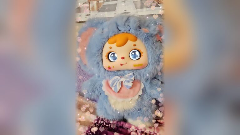 Dr. Elena’s blue elephant-costume Samuel plush with pink ears and a striped bow, shown in her own video.